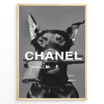 Indlæs billede til gallerivisning Fashion Plakat | Edgy Chanel-Inspired Art Featuring Dog with Gun Plakaty.dk | Black dog with spiked collar holding a handgun in its mouth, with the word &quot;CHANEL&quot; overlaid in bold white text.
