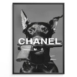 Indlæs billede til gallerivisning Fashion Plakat | Edgy Chanel-Inspired Art Featuring Dog with Gun Plakaty.dk | Black dog with spiked collar holding a handgun in its mouth, with the word &quot;CHANEL&quot; overlaid in bold white text.

