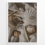 Indlæs billede til gallerivisning Fashion Plakat | Elegant Chanel-Inspired Flat Lay with Seashells and Jewelry Plakaty.dk | Flat lay of elegant seashells, a pearl bracelet, and gold jewelry on soft ivory fabric with the Chanel logo centered.
