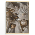 Indlæs billede til gallerivisning Fashion Plakat | Elegant Chanel-Inspired Flat Lay with Seashells and Jewelry Plakaty.dk | Flat lay of elegant seashells, a pearl bracelet, and gold jewelry on soft ivory fabric with the Chanel logo centered.
