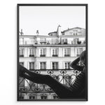 Indlæs billede til gallerivisning Fashion Plakat | Elegant Woman Relaxing on Parisian Balcony – Black and White Photography Plakaty.dk | Black and white photo of a woman relaxing on a Parisian balcony with classic building architecture in the background
