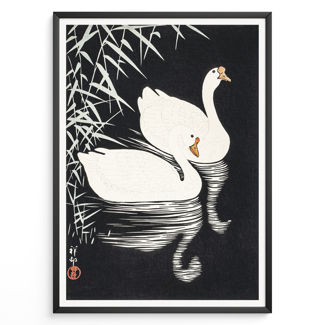 Framed Japanese Ukiyo-e style art poster showing two white swans gliding on dark water with bamboo leaves above.