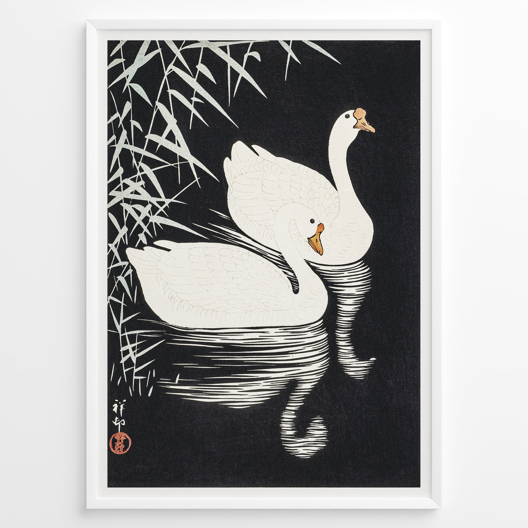 Framed Japanese Ukiyo-e style art poster showing two white swans gliding on dark water with bamboo leaves above.
