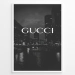 Indlæs billede til gallerivisning Fashion Plakat | Gucci Cityscape Black &amp; White Fashion Poster Plakaty.dk | Black and white poster with the Gucci logo over a night cityscape featuring tall buildings and water reflections.
