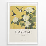 Indlæs billede til gallerivisning Japanske plakater | Japanese woodblock print of white trumpet lilies with green leaves and two sparrows flying against a yellow background, based on Hokusai’s  floral artwork.
