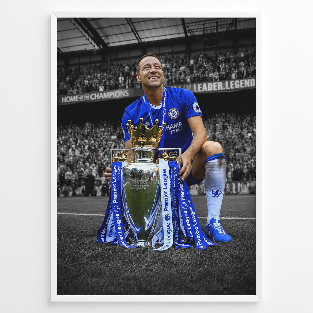 John Terry wearing a Chelsea football jersey with the Premier League trophy in front of the Chelsea supporters. The iconic blue colors stand out against the black and white stadium background.