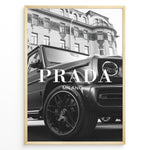 Indlæs billede til gallerivisning Fashion Plakat | Luxury Lifestyle: Mercedes G-Wagon x Prada Milano Wall Art Plakaty.dk | Black and white framed photo of a Mercedes G-Wagon with Prada Milano text overlay, parked in front of ornate historic buildings.
