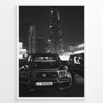 Indlæs billede til gallerivisning Fashion Plakat | Midnight Luxury – Brabus G-Wagon in Dubai Plakaty.dk | Black and white photo of a Brabus G-Wagon parked in front of the Dubai skyline at night, with skyscrapers like Burj Khalifa and EMAAR towers in the background.
