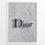 Indlæs billede til gallerivisning Fashion Plakat | Minimalist Dior Wall Sign – Timeless Fashion Statement Plakaty.dk | Minimalist black Dior logo mounted on a textured white wall, casting a soft shadow and evoking luxury and elegance.
