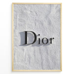 Indlæs billede til gallerivisning Fashion Plakat | Minimalist Dior Wall Sign – Timeless Fashion Statement Plakaty.dk | Minimalist black Dior logo mounted on a textured white wall, casting a soft shadow and evoking luxury and elegance.
