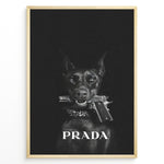 Indlæs billede til gallerivisning Fashion Plakat | Prada-Inspired Art Featuring Fierce Dog with Gun Plakaty.dk | Black Doberman with a studded collar holding a handgun in its mouth, set against a dark background with the word &quot;PRADA&quot; in bold white text.
