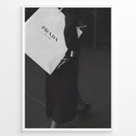 Indlæs billede til gallerivisning Fashion Plakat | Prada Shopping Bag Fashion Photography Wall Art Plakaty.dk | Black and white photo of a person holding a large Prada Milano shopping bag, dressed in elegant dark clothing.
