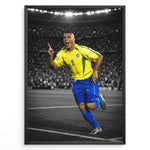 Indlæs billede til gallerivisning Ronaldo Nazário i den klassiske gule Brasilien-trøje med nummer 9, hvor han fejrer på fodboldbanen. Motivet har en sort-hvid stadionbaggrund med fremhævede brasilianske farver.
