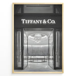 Indlæs billede til gallerivisning Fashion Plakat | Tiffany &amp; Co. Entrance – Luxury Jewelry Store Poster in Black &amp; White Plakaty.dk | Black and white photo of the Tiffany &amp; Co. boutique entrance with glass doors, a chandelier inside, and the illuminated brand name above.
