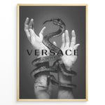 Indlæs billede til gallerivisning Fashion Plakat | Versace-Inspired Art Featuring Serpent and Marble Hands Plakaty.dk | Black-and-white image of a snake wrapped around two upward-reaching marble-textured hands, with the word &quot;VERSACE&quot; overlaid in bold, semi-blurred text.
