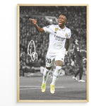 Indlæs billede til gallerivisning Framed plakat of Vinícius Jr. in a Real Madrid kit celebrating with a pointing gesture, color-highlighted against a black and white background with signature
