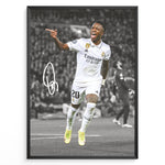Indlæs billede til gallerivisning Framed plakat of Vinícius Jr. in a Real Madrid kit celebrating with a pointing gesture, color-highlighted against a black and white background with signature
