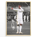 Indlæs billede til gallerivisning Framed plakat of Vinícius Jr. in a Real Madrid kit doing an eye-cover celebration, with a black and white background and printed signature
