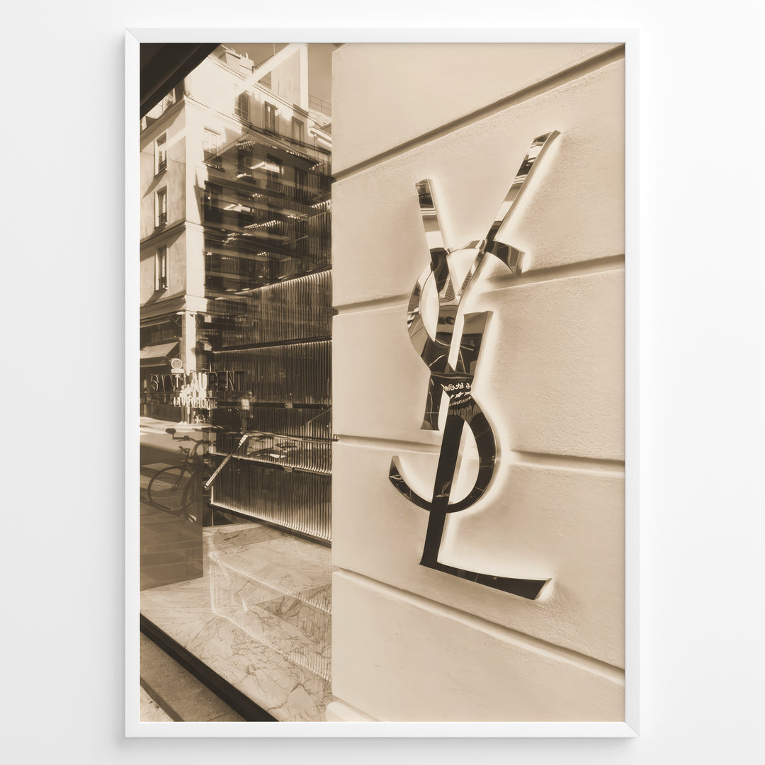 Fashion Plakat | Yves Saint Laurent Sepia Storefront – Vintage Luxury Wall Art Plakaty.dk | Sepia-toned photo of the Yves Saint Laurent storefront with a prominent YSL logo on a white wall and reflections of the cityscape in the background.